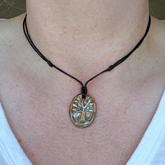 HANDMADE Tree of Life Ceramic Pendant Necklace N E C K L A C E ∙ D E T A I L S Ceramic Pendant: handmade, 30 mm x 22mm oval, flat back, approx 3.5mm thick Cord: 1.5mm Black Poly Cord - water-resistant  Closure: Sliding Knot Size: adjustable from 16 - 30 inches long Wear this beautiful stoneware hand-painted Tree of Life Pendant in tones of brown, blue, and cream as a 16" necklace or up to 30 inches in length - great for all occasions The ceramic pendant is handmade & painted in Spain   C A R E: Submersion in water should be avoided. Perfumes, Sunscreen, moisturizers, and harsh Chemicals may cause damage. D E L I V E R Y:  Your  Necklace will be packaged in a muslin bag inside a jewelry gift box and shipped in a bubble bag for protection.  Please see your order receipt or my Shipping & Poli Adjustable Nature-inspired Necklace For Gift, Adjustable Necklace With Sliding Knot For Gifting, Artisan Jewelry With Adjustable Cord As Gift, Gift Round Pendant Necklace With Sliding Knot, Nature-inspired Jewelry With Adjustable Cord And Pendant, Nature-inspired Pendant Jewelry With Adjustable Cord, Waxed Cord Jewelry With Round Pendant As Gift, Waxed Cord Jewelry With Round Pendant For Gift, Artisan Jewelry With Adjustable Length As Gift