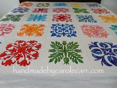 a colorful quilt on a bed with white sheets