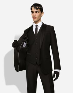 Refined and tailored three-piece wool tuxedo suit with silk satin details. Regular Martini fit Jacket with peak lapels, welt pockets, a breast pocket, and three inner pockets Single-breasted fastening with a double button, lined V-neck vest with five buttons Pants with front slant pockets, rear buttoned welt pockets and satin side bands The jacket measures 73.5 cm - 28.9 inches from the back collar seam on a size IT 48 The crotch measures 17.5 cm - 6.9 inches and the hem is 18 cm - 7.1 inches wide on a size IT 48 The model is 185 cm - 72.8 inches tall and wears a size IT 48 Made in Italy Tuxedo With Suit Collar For Gala, Gala Tuxedo With Suit Collar, Luxury Fitted Three-piece Suit, Tailored Elegant Three-piece Suit For Evening, Elegant Tailored Three-piece Suit For Evening, Black-tie Gala Tuxedo Suits, Tuxedo For Black-tie Events And Galas, Luxury Fitted Suits For Gala, Luxury Fitted Single Breasted Three-piece Suit