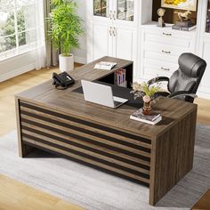 an office desk with a laptop and phone on it