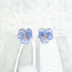 Handmade Spring Blue Pansy Flower Earrings Add a touch of spring to your look with our handmade blue pansy flower earrings! These stunning earrings feature a delicate pansy shape, perfect for any spring-themed outfit. Give the gift of floral beauty to yourself or a loved one. Order now and embrace the beauty of nature! As a gift shop, we offer a complimentary gift box for every order. Some details Size of flower: around 10mm x 12mm; Materials: studs: sterling silver The pansy flower: resin Note: Blue Pansy Flower, Blue Pansy, Pansy Flower, Pansies Flowers, Themed Outfits, Pearl Gemstone, Stunning Earrings, Flower Gift, Pansies