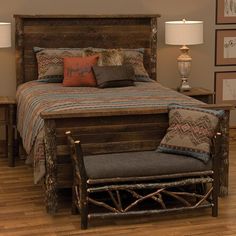 a bed with wooden headboard and foot board sitting in a room next to two lamps