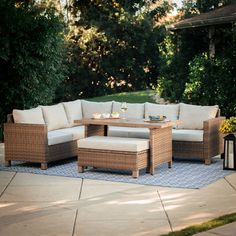 an outdoor patio with wicker furniture and blue rug