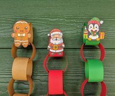 three rolls of toilet paper are lined up on a green wooden surface with christmas decorations