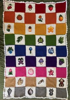 a crocheted blanket with many different items on it