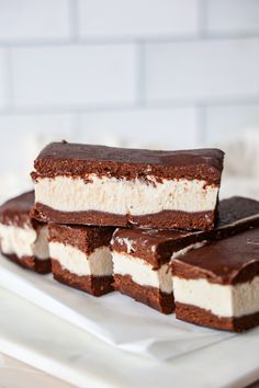 four pieces of cake sitting on top of a white plate next to some chocolate and marshmallows