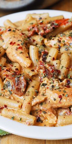 a white plate topped with pasta covered in sauce