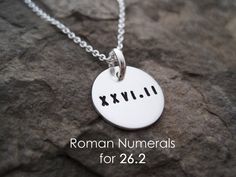 a silver necklace with roman numerals on it and the word xyrii written in cursive font