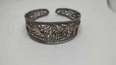 Beautiful antique bracelet made by sterling silver worked in filigree tehnique, no hallmarks, been tested with acid for silver,with time patina In great condition Weight 30grams All of our pieces are in pre-loved, vintage or antique condition, with signs of age and wear preserved as a mark of authenticity. Unique Filigree Bangle Cuff Bracelet, Antique Oxidized Cuff Bracelet As Gift, Antique Oxidized Cuff Bracelet For Gift, Antique Oxidized Finish Cuff Bracelet As Gift, Ornate Engraved Cuff Bracelet, Handmade Ornate Cuff Bracelet, Ornate Bangle Cuff Bracelet With Intricate Design, Ceremonial Silver Filigree Bangle, Collectible Cuff Bracelet Bangle With Intricate Design