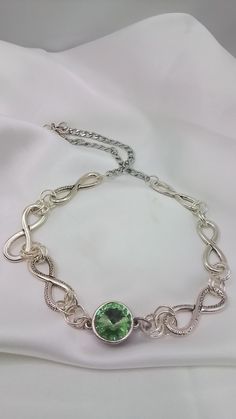 A Sparkling silver chain and link necklace. Made with several large pewter links joined with small silver rings showing off a gorgeous peridot crystal center gem which is encased in a filigree style bezel. It's ended with a stylish stainless chain. This necklace is  perfect Birthday gift for the August Birthday as Peridot is August birthstone. A thoughtful gift for your love's birthday. It's great for everyday wear or a special occasion.  Dazzling Lightweight and finished with a sturdy chain... The center peridot green crystal gem is encased in a filigree design base. This unique  modern design necklace measures 18 inches. Ready to send to you. My pieces are one of a kind.  This one ships free .... Formal Peridot Gemstone Necklaces, Handmade Silver Peridot Necklace, Elegant Peridot Nickel-free Jewelry, Nickel-free Peridot Round Jewelry, Exquisite Sterling Silver Multi-stone Necklaces, Infinity Necklace Silver, Peridot Crystal, Silver Necklace Statement, Peridot Green