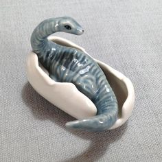 a ceramic figurine of a blue and white sea horse sitting in a bowl