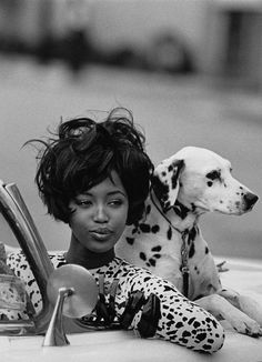 a black and white photo of a woman with a dalmatian dog