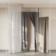 an empty room with curtains and two windows