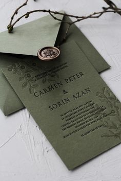 a close up of an envelope with a wax stamp on it and some branches in the background