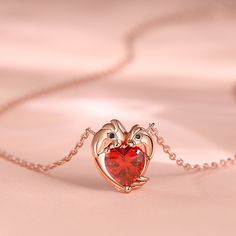 The two parrots on the pendant are tenderly joined together. A brilliant red heart-shaped stone sparkles at the center, capturing your burning love. It shines like the beating heart of your romance, a testament to the enduring love that intertwines your hearts. Embrace the romance woven into this necklace, as it becomes the physical embodiment of your love story.Carat Weight: 2.55 ctStone Size: 7*7 mmStone Type: Jeulia® StoneNumber of Stones: 1 Stone Shape: HeartStone Color: Garnet RedCarat Weig Valentine's Day Birthstone Heart Pendant Jewelry, Valentine's Day Heart Pendant Jewelry With Birthstone, Red Heart-shaped Birthstone Jewelry, Valentine's Day Heart Pendant Necklace With Birthstone, Valentine's Day Birthstone Heart Pendant Necklace, Red Open Heart Birthstone Jewelry, Red Heart Necklace With Birthstone As Gift, Red Heart Necklace With Birthstone For Gift, Heart-shaped Gemstone Jewelry For Valentine's Day