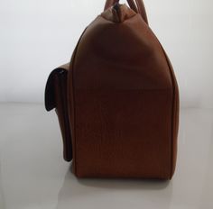 Vintage brown imitation leather sportsbag / weekend bag from the 70s In good condition 2 front pockets Sizes H xW x D ± 35 x 51 x 21 cm Vintage Brown Weekender Bag For Travel, Handmade Vintage Brown Travel Bag, Vintage Brown Travel Bag With Leather Lining, Vintage Brown Travel Bag With Leather Trim, Shabby Chic Table Lamps, Vintage Brown Leather-handled Travel Bag, Shabby Chic Table, Wooden Coat Rack, Hat Box