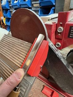 a person using a grinder to cut wood with a circular blade on the table