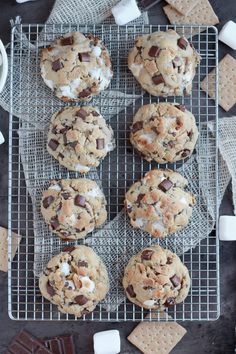 chocolate chip cookies with marshmallows on a cooling rack next to graham crackers