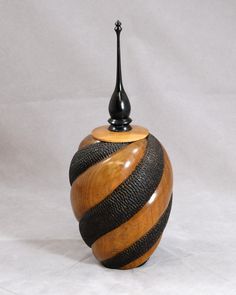 a black and brown vase with a wooden top