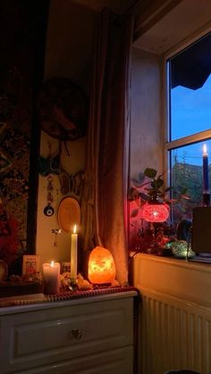 a room with a window that has candles on the windowsill and decorations around it