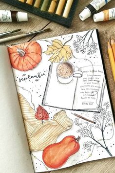 an open notebook with autumn drawings and colored pencils