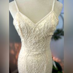 a white wedding dress on display in front of a mannequin's head