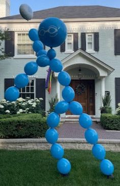 a blue balloon sculpture in front of a house