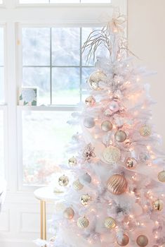 a white christmas tree with gold and silver ornaments