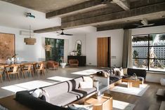 a living room filled with lots of furniture next to a dining room table and chairs