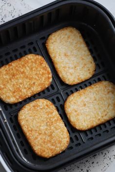 four fried food patties in a black pan