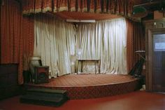 an old fashioned stage set with curtains on the sides and a table in the middle