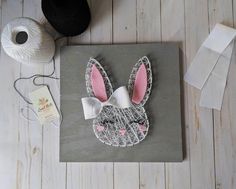 an easter card with bunny ears and a white bow on it, next to some yarn