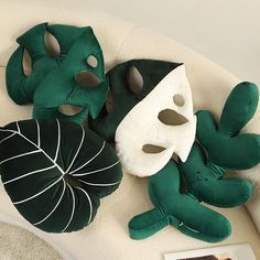 two green and white masks sitting on top of a couch next to a framed photo