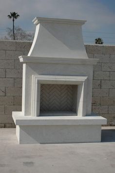 a large white fireplace sitting on top of a cement slab