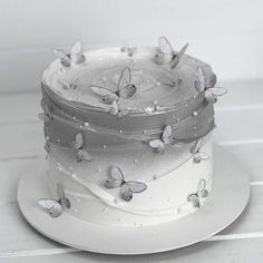 a white cake with silver butterflies on it