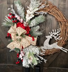 a christmas wreath with a deer and holly on it next to a wooden door hanger