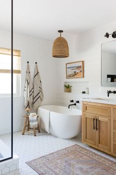 a white bath tub sitting next to a wooden cabinet in a bathroom on top of a rug