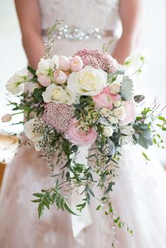 a bridal holding a bouquet of pink and white flowers