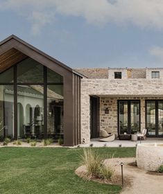 a house with a pool in front of it and grass around the back yard area