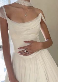 a woman in a white dress with her hand on her hip and wearing a diamond ring