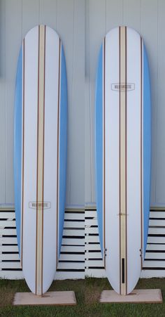 two blue and white surfboards standing next to each other