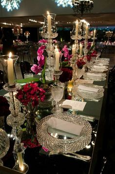 the table is set with candles, plates and place settings for dinner guests to enjoy