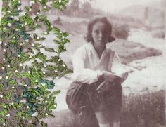 an old photo of a woman sitting on the ground with flowers in her hair and green leaves around her neck