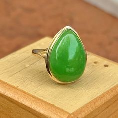 Estate 14KT Yellow Gold Teardrop Pear Jade Large Green Bezel Set Band Ring Beautiful, vibrant, dyed green jade!  Size 7 Weight: 3.73 grams Band width: 2mm Genuine jade measures: 20mm x15mm stamped 14KT  Excellent estate condition This is a great ring. Unique, well made Please take a look at our other jewelry items. Thank You, Legacy Saint Jewelry -OUR RETURN POLICY-  To return an item you must first contact us within 7 days of receiving your item(s). Upon messaging us we will provide the steps in returning or exchanging. The buyer is fully responsible for paying for return shipping. We offer refunds minus $10 or 10% of the item cost (plus any mandatory taxes), whichever is greater will be subtracted from the refunded amount. Your refund will post back to you within 7 business days of recei Green Pear-shaped Emerald Gemstone Ring, Green Pear-shaped Emerald Ring, Classic Green Teardrop Emerald Ring, Green Teardrop Emerald Ring For May Birthstone, Green Teardrop Ring For May Birthstone, Teardrop Green May Birthstone Ring, Green Teardrop May Birthstone Ring, Fine Jewelry Green Pear-shaped Ring, Green Teardrop Fine Jewelry Ring