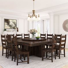 a dining room table surrounded by chairs and a vase with flowers on it in front of a chandelier