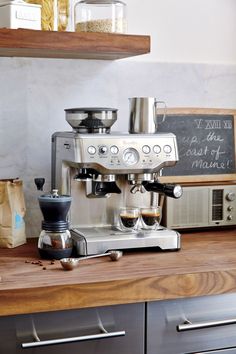 an espresso machine sitting on top of a wooden counter