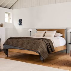 a bed sitting on top of a wooden floor next to a fire place in a bedroom