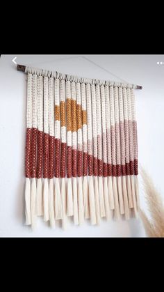 a wall hanging made out of white and red beads with a brown star on it