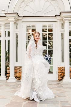 a woman in a white wedding dress is posing for the camera with her hands on her hips