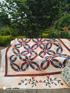 a quilt is laying on the ground next to a tree